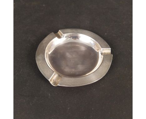 An Art Deco silver ashtray with engine turned border, hallmarked London 1939, makers mark Harrods Ltd, approx 42g