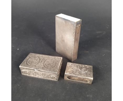 A large silver matchbook holder with engine turned decoration, a smaller matchbox holder plus a white metal lidded box with f