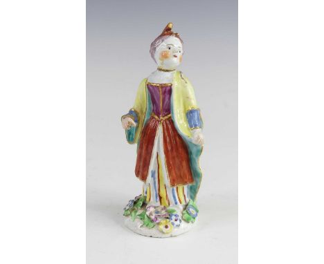 A Bow porcelain figure of a girl, circa 1760, shown in colourful dress standing upon a floral encrusted base, red enamel anch