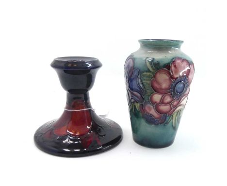 A Moorcroft vase tubeline decorated in the anenome pattern, h.10cm, together with a Moorcroft candlestick in the pomegranate 