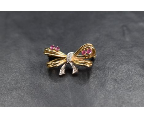 A 9ct gold brooch modelled as a small bow having diamond and ruby chip decoration, approx 3.2g