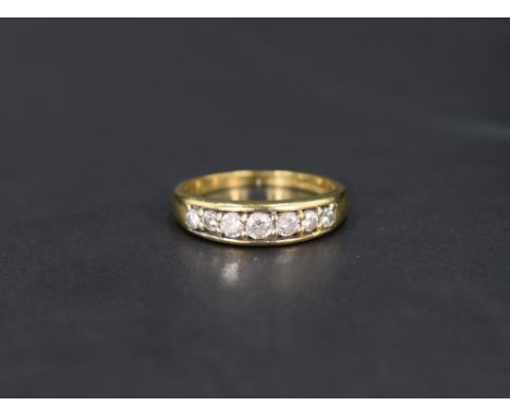 A diamond half eternity ring having seven diamonds in a channel setting on an 18ct gold loop, size O &amp; approx 4.2g