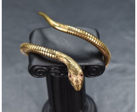 A 9ct gold flexible snake bangle, with ruby set eyes and decorative engraving to the head and tail, marked 375, approx 27.1g 