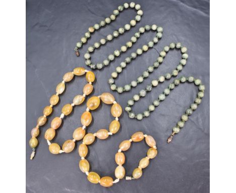 Two stone beaded necklaces, comprising a graduated yellow tone agate necklace of oval beads and a nephrite jade necklace of c