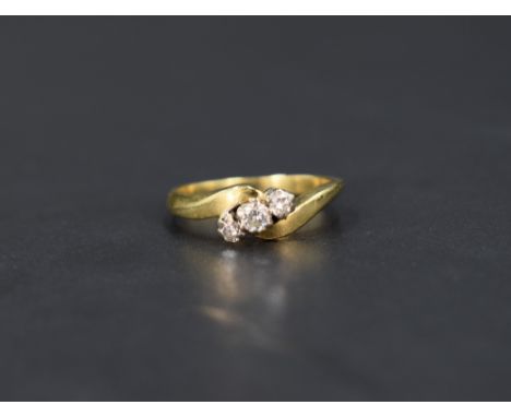 A diamond trilogy ring, the graduated diamonds with twist shoulders on an 18ct gold shank, ring size K-I and approx 4g