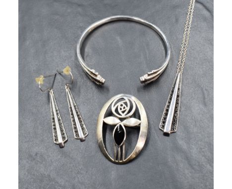 A set of silver jewellery by Kit Heath comprising pendant, earrings and bangle, all having jet decoration, and a brooch of Re