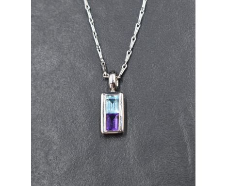 A 9ct white gold pendant having blue topaz and amethyst style stones in a rectangular mount on a 9ct white gold paperlink cha