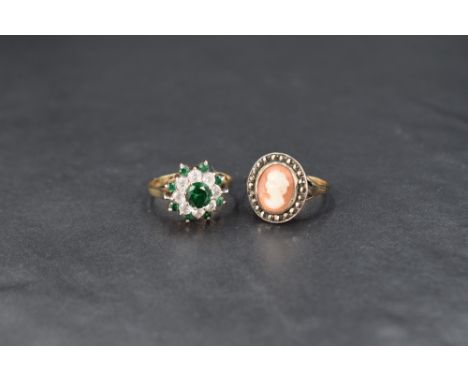 Two 9ct gold rings comprising a green and white paste cluster ring on a 9ct gold shank and a cameo ring having a marcasite bo