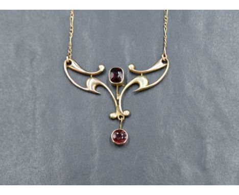 An Edwardian style pendant stamped 9ct having garnet decoration on a fixed chain, approx 17' &amp; 5.2g