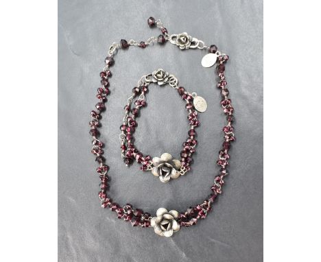 A rough cut garnet necklace and matching bracelet by Yvonne Christa of New York, both having central silver roses and hook &a