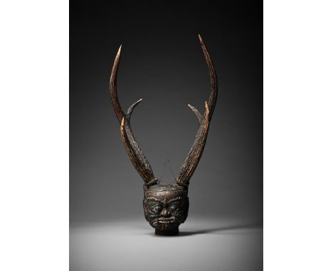 AN ASIAN ONI SKULL POSSIBLY DEPICTING BARONG  POSSIBLY INDONESIAN, LATE 19TH CENTURY  Carved wood head with traces of polychr