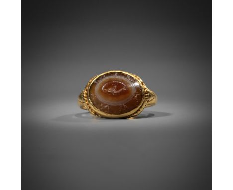 AN ANCIENT ROMAN GOLD AND AGATE INTAGLIO RING  2nd - 3rd Century AD The oval agate panel with a central dolphin intaglio with