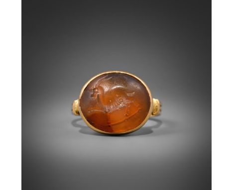 A CORNELIAN INTAGLIO RING  POSSIBLY 3-5TH CENTURY  The intaglio possibly Roman or further East, with an ibex like beast withi