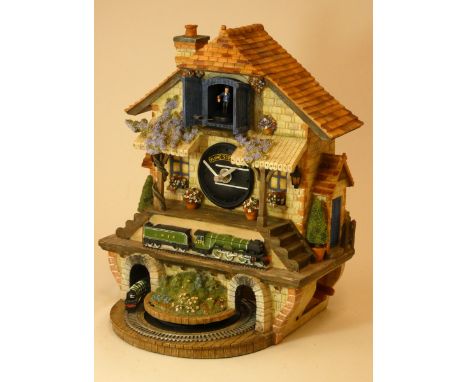 A limited edition Flying Scotsman musical cuckoo clock, made from ceramic and painted resin, depicting a railway station scen