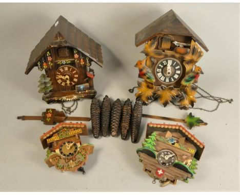 A German made mid Century cuckoo clock, together with a similar example and two miniature Swiss chalet novelty wall clocks. (