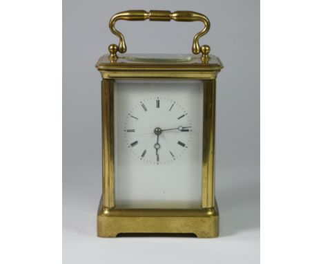A large brass carriage clock, white enamel dial with Roman numerals, 15cm 