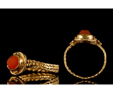 Ca. 100-300 ADA flat-section gold hoop with herringbone wire borders and beaded median band; an applied discoid bezel with fi