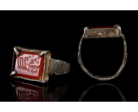 Ca. 1370-1507 ADAn ancient Islamic Timurid silver ring with thin band and rectangular bezel holding a carnelian intaglio insc