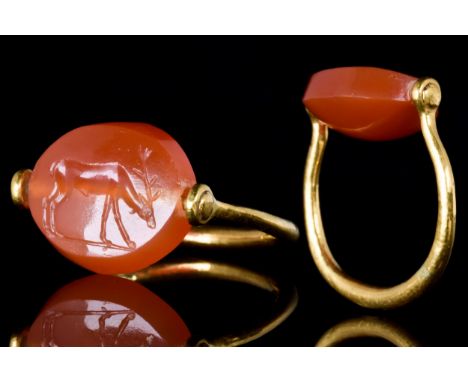 Ca. 400-300 BCA carnelian flat scaraboid set in a gold swivel ring. The scaraboid decorated on the flat side with a deer with