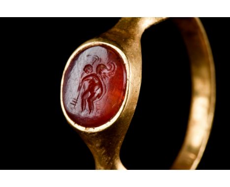 Ca. 100-300 ADA gold ring comprising a slender hoop with scooped shoulders, supporting raised bezel inset with carnelian inta