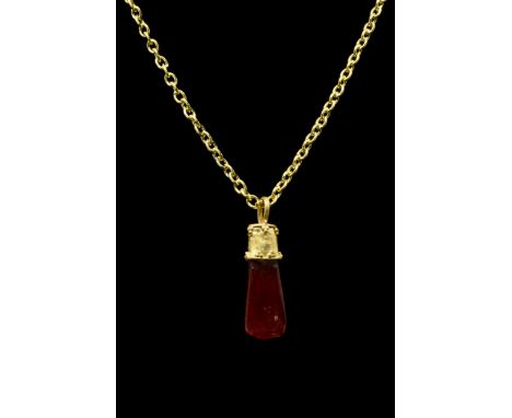 Ca. 100-300 ADA carnelian stone pendant topped with a gold cap with suspension loop, raised edges, and decorated with cluster