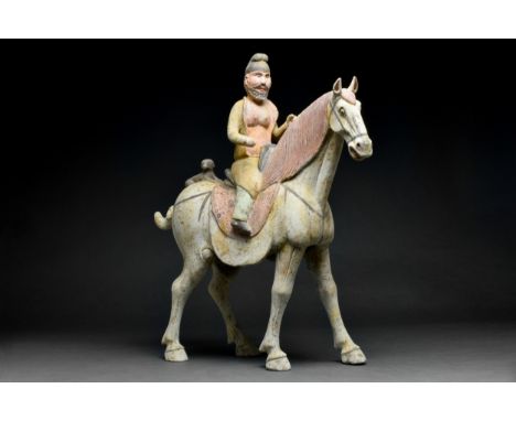 Tang Dynasty, Ca. 618-907 AD An earthenware mingqi of foreign rider on a horse modelled in a standing pose. The rider depicte