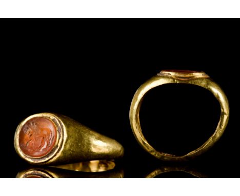 Ca. 200-300 ADA gold ring with a plain band expanding towards an oval bezel inset with carved carnelian intaglio depicting a 