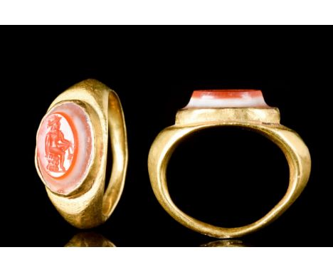 Ca. 100-300 ADA gold finger ring of carinated profile and expanded shoulders, high elliptical bezel set with a stone intaglio