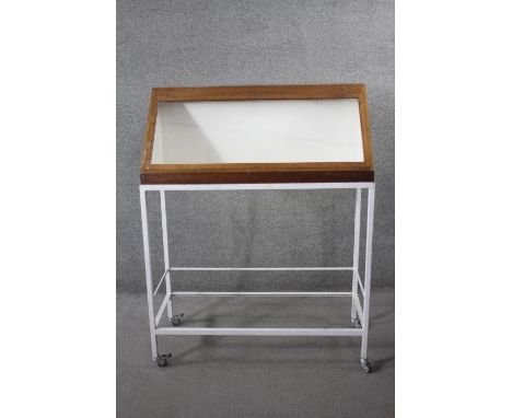 A lidded glazed mahogany display case on metal framed stand fitted with locking castors, from the Blizard Club; The Royal Hos