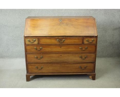 A Georgian mahogany bureau with fall front revealing satinwood and olivewood inlaid interior above four long graduating drawe