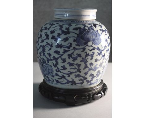 A large Chinese blue and white lidded ginger jar with double happiness and stylised foliate design. Sitting on a carved and p