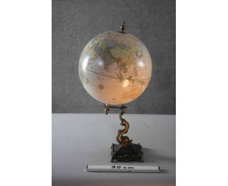 A Victorian style globe on brass dolphin design stand. H.53 Diameter.29cm.