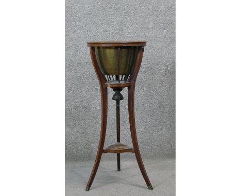 A 19th century mahogany jardiniere stand with brass liner on swept supports. H.90 Diam.37 cm (Damaged as seen). 