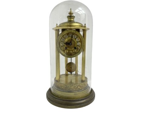 French - early 20th century 8-day portico clock under a glass dome, on a shaped circular brass base with a decorative repouss