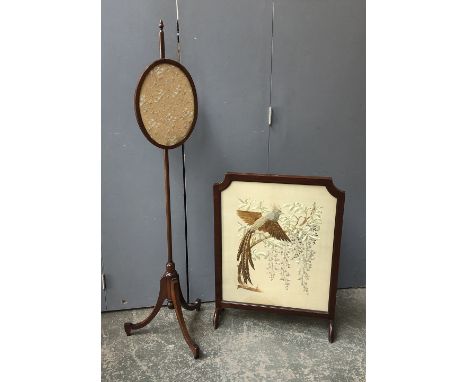 A glazed embroidered fire screen depicting a fancy bird, 67cmW; together with a pole fire screen, 144cmH 