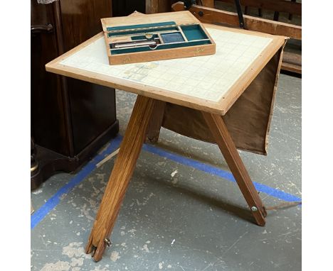 A cartographers table/easel together with a box of cartography tools