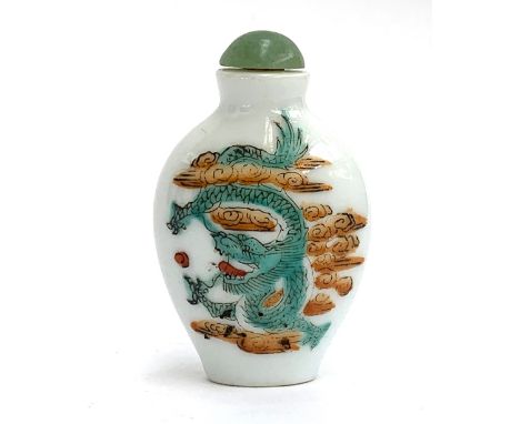 A small Chinese glass snuff bottle, painted with a dragon amongst ruyi clouds, with jade stopper, red character marks to base