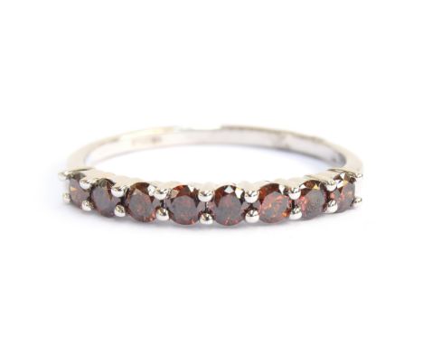 A 9ct white gold band set with eight red diamonds, total carat weight 0.75cts, size T 1/2, gross weight 2.1gProvenance: priva