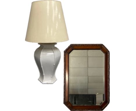 An early 20th century oak wall mirror with the original bevelled plate in a carved octagonal frame, along with a mid century 