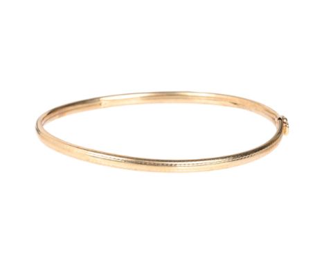 A 9ct gold hinged bangle, band width 3.5mm, internal circumference 17cm, 3.3g . Condition Report:General wear to high points 