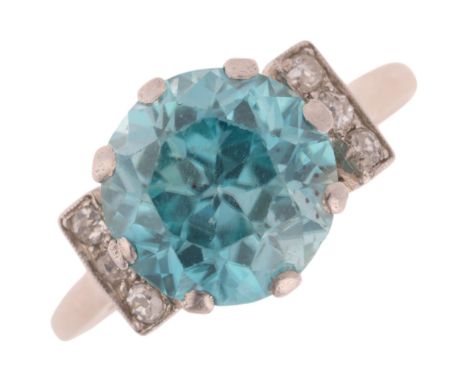An Art Deco 9ct white gold blue zircon and diamond dress ring, claw set with round-cut zircon flanked by old-cut diamond shou