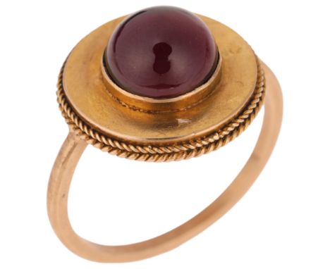 An Antique Victorian Etruscan Revival garnet mourning ring, circa 1880, centrally set with foil-back round cabochon garnet, w