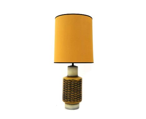 A West German brutalist pottery table lamp,1970s, with a cylindrical base, in a mustard coloured glaze, decorated with scallo