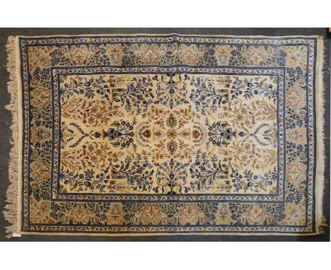 A Kirman carpet,decorated with precious objects to a pale field and navvy border,340cm x 245cmLosses to the tassels. Some mar