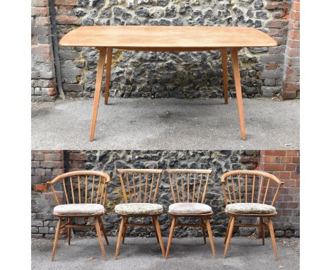 A mid century light elm Ercol dining table and chairs, the table of rectangular form with tapering legs, with label to unders