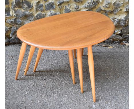 A nest of three Ercol elm and beech pebble tables, largest 40 cm high x 64 cm wide 