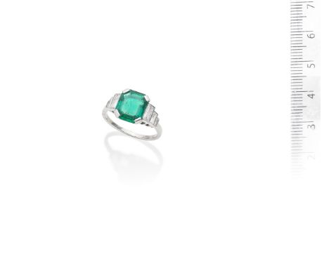 An emerald and diamond ring, circa 1935The step-cut emerald, weighing 2.55 carats, between tapered baguette-cut diamond shoul