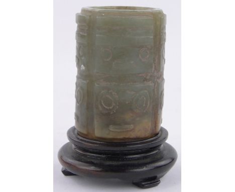 A Chinese relief carved jade cylindrical pot,height 6cm, diameter 4cm, hardwood stand.