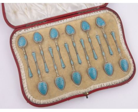 A set of 12 Norwegian silver gilt and champleve enamel coffee spoons,makers marks E C K, original red leather case.