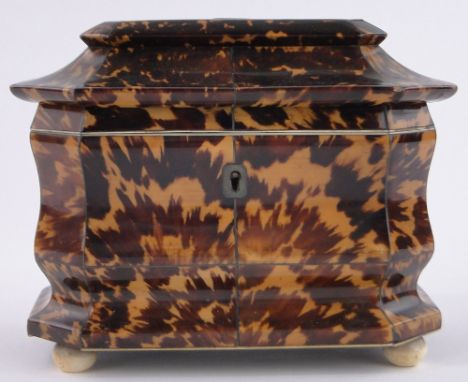 An early 19th century tortoiseshell tea caddy,inlaid silver stringing, tortoiseshell inner lids resting on ivory bun feet, le